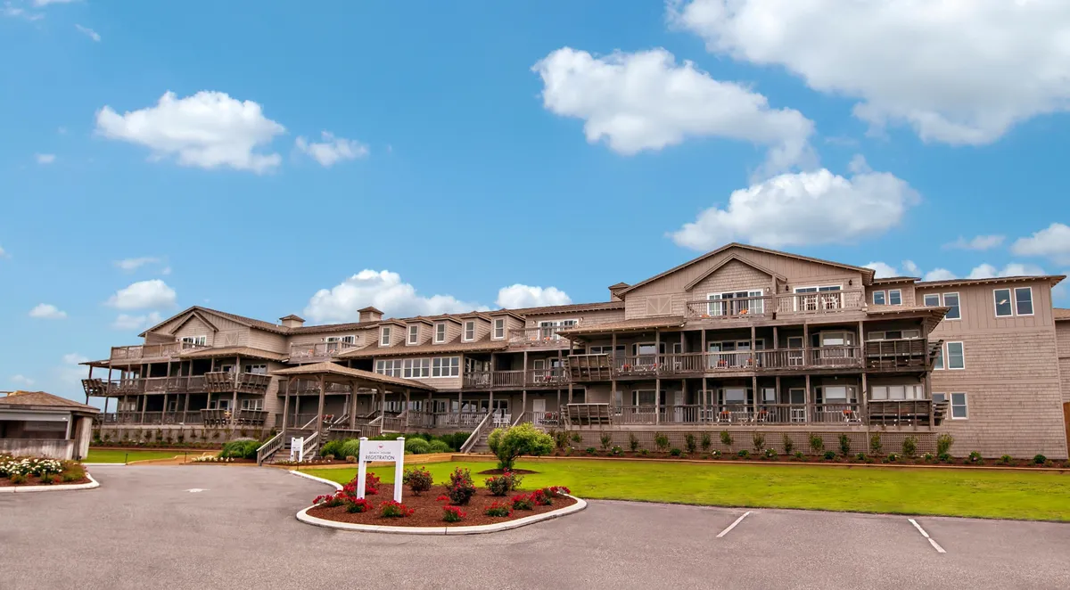This exterior image highlights the building's architecture and prominently features private balconies overlooking landscaped gardens. The vantage point suggests the balconies offer sweeping views and exclusive outdoor spaces ideal for relaxation.